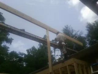 Carpenter setting a ridge beam over a new addition frame — Ice Dam Removal by Roofing Brothers in Avalon