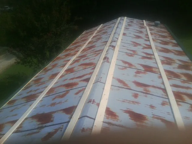 Rusted metal roof panels with new wood purlins before replacement — Storm Damage Roof Repair in Avalon by Roofing Brothers