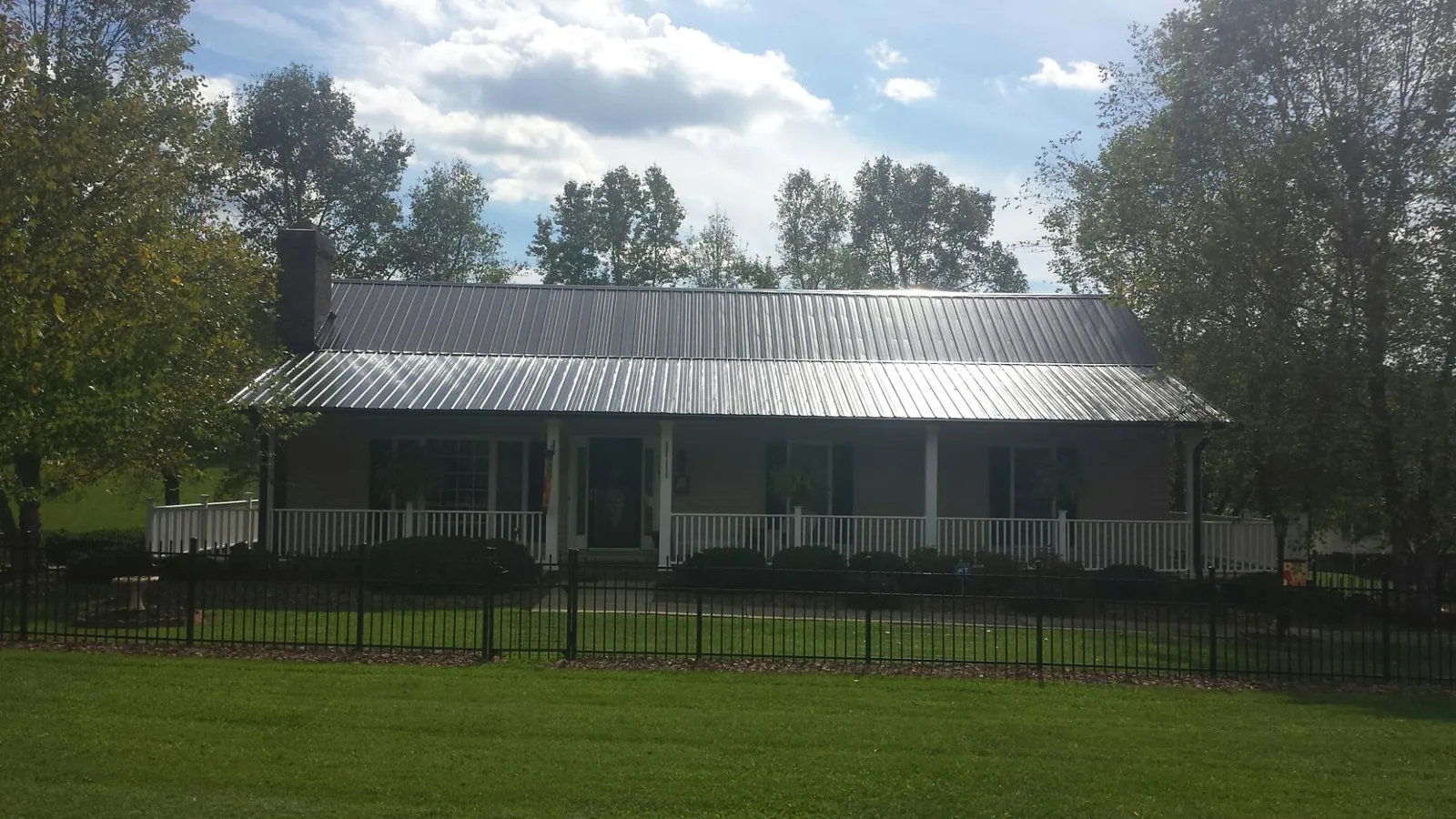 Gray metal roof on a brick ranch with a full width front porch — Gutter Guard Installation work by our crew in Avalon